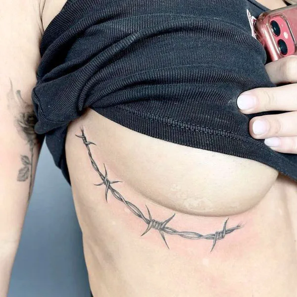 Barbed wire under boob tattoo