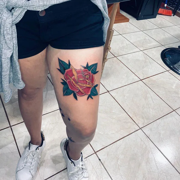 December birth flower tattoo on above knee