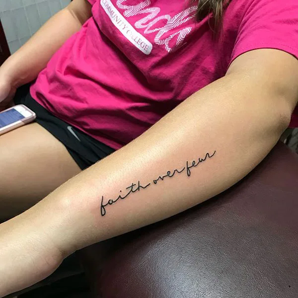 Faith over fear tattoo on forearm