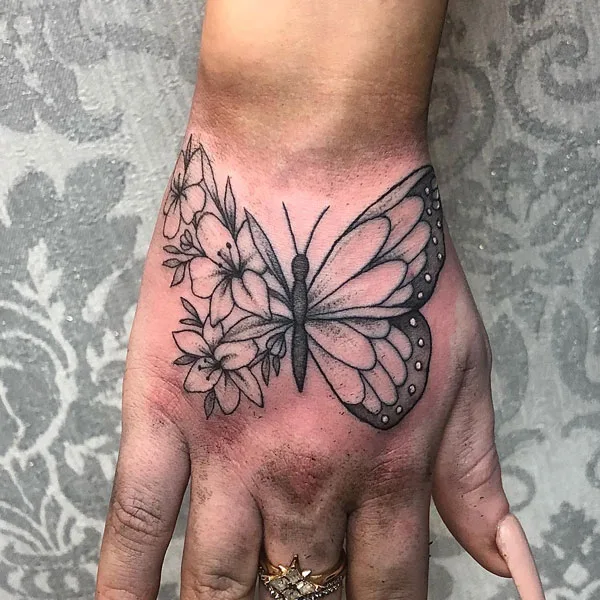 Half butterfly half flower tattoo on hand