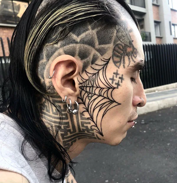 Spider web face tattoo