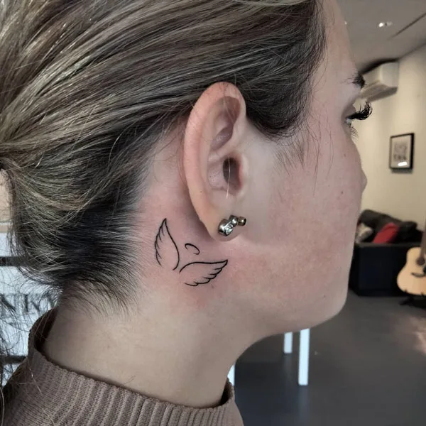 Angel wings tattoo behind the ear